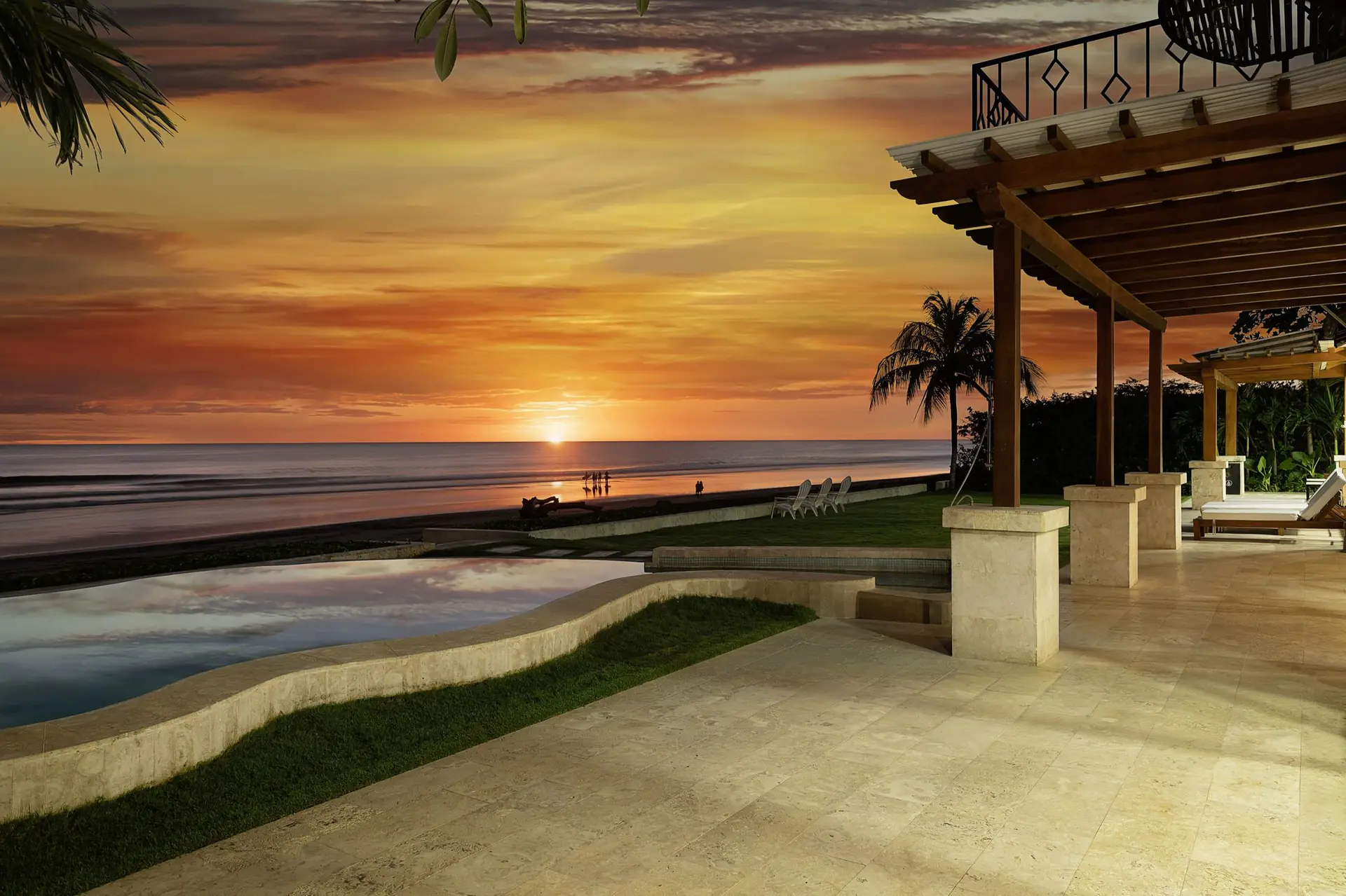 Sunset over the pool and oceanfront lawn at Casa Colorados