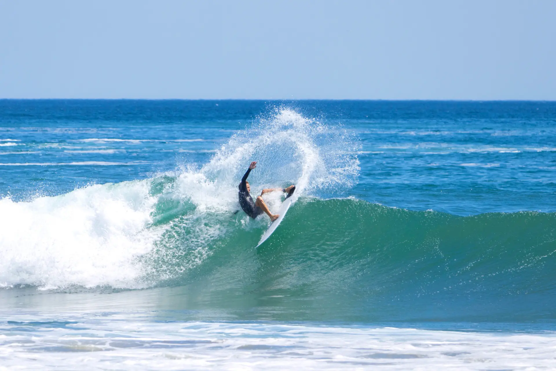Surfer carving a turn at Playa Colorado